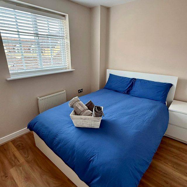 A bedroom at Hammond House, with a made bed, storage and a window.