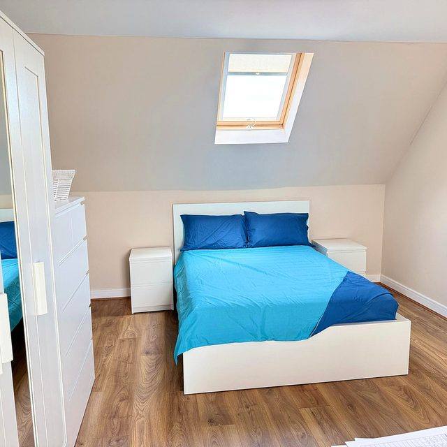 The loft bedroom at Hammond House, set under a sloping ceiling with its own window.