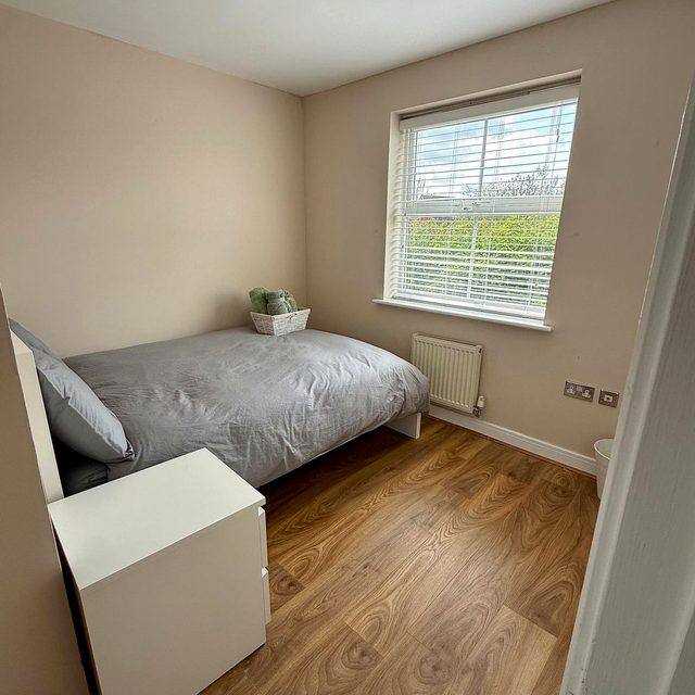 A single bedroom at Hammond House with a bed, desk and wardrobe.