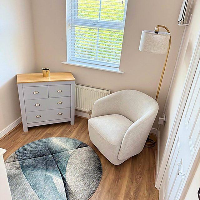 A reading corner in one of the bedrooms, with a chair and shelving.