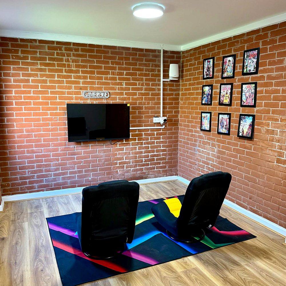 A games room at Hammond House with seating and a screen.
