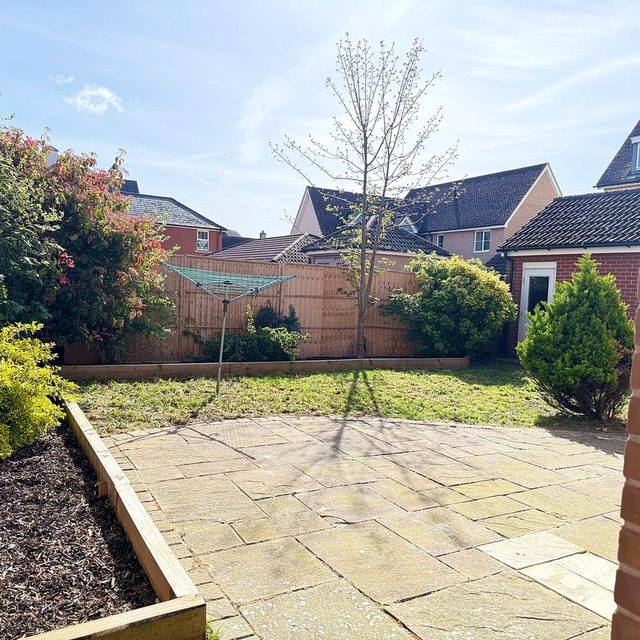 The enclosed rear garden at Hammond House, with lawn, paving and planted borders.